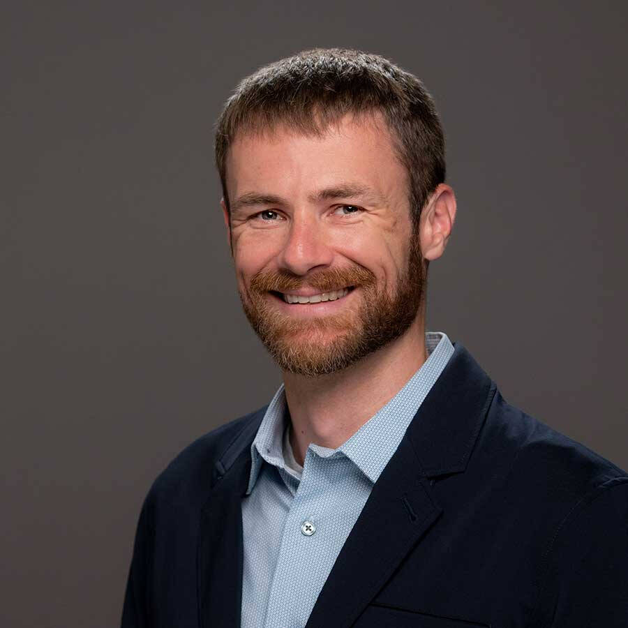 Dr. Moore wearing a light blue shirt and a navy suit jacket